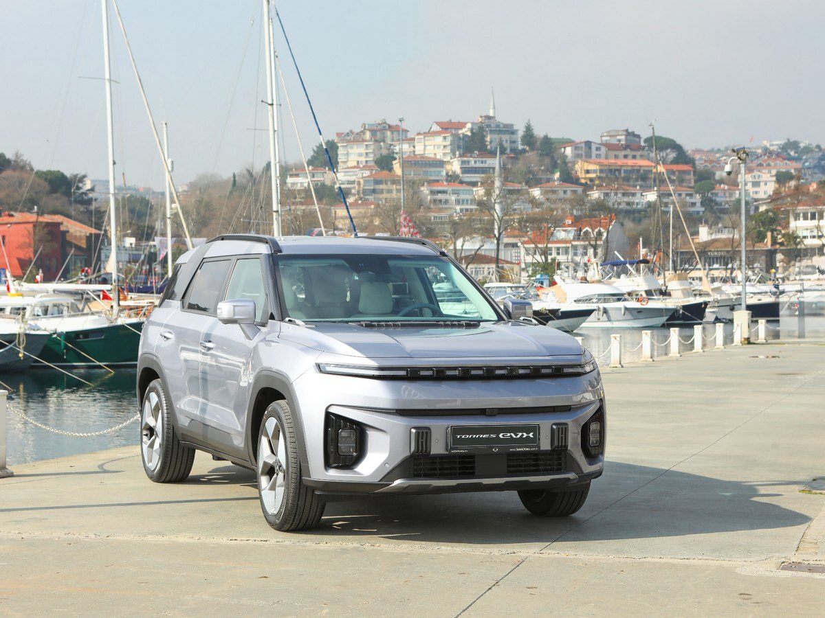 KGM Torres EVX, električni SUV, parkiran ob marini z jadrnicami
