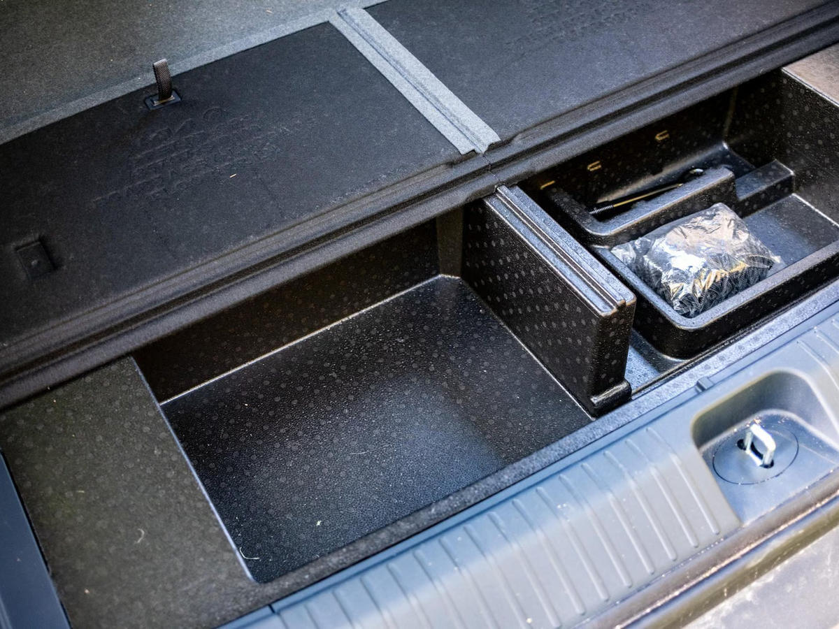 Dodatni odlagalni predali pod dnom prtljažnika električnega modela Kia PV5 Passenger.